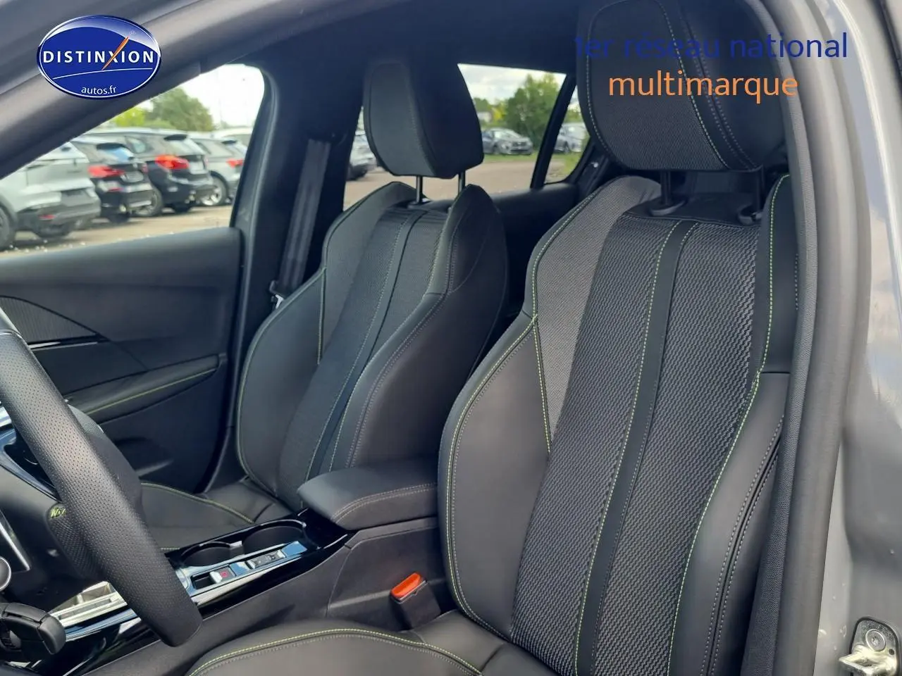 Vue intérieure côté conducteur des sièges sport en tissu et cuir gris avec surpiqûres vertes d'une Peugeot 208 1.2 hybrid 136 GT.