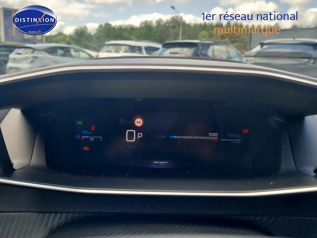 Tableau de bord numérique du Peugeot 208 gris, affichant la vitesse, la jauge et les alertes en vue frontale.