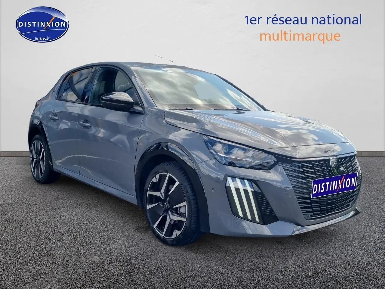 Peugeot 208 gris vue 3/4 avant droit, avec phares LED et jantes alliage distinctives.