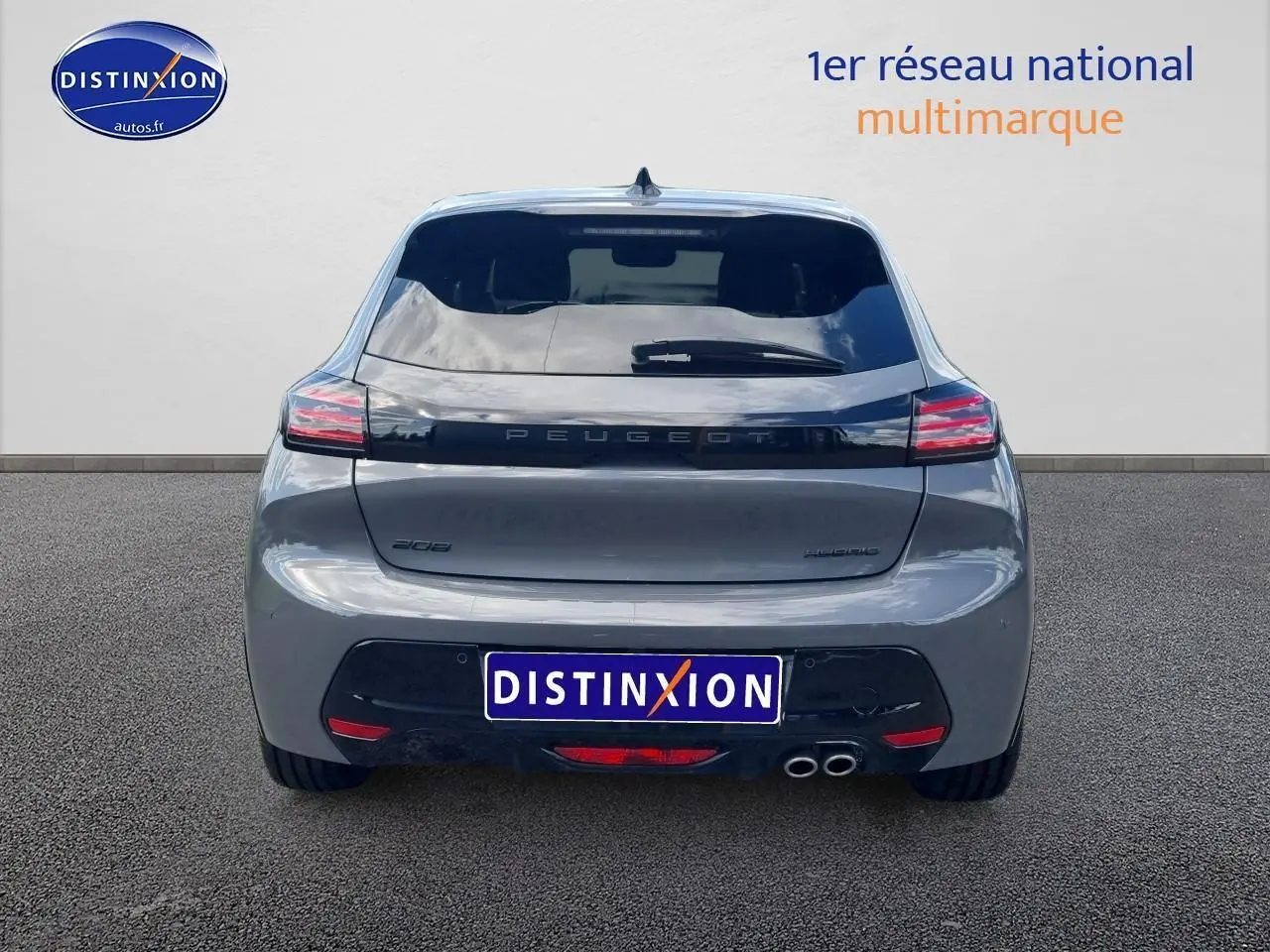 Vue arrière d'une Peugeot 208 gris métallisé avec feux LED et double sortie d'échappement chromée.