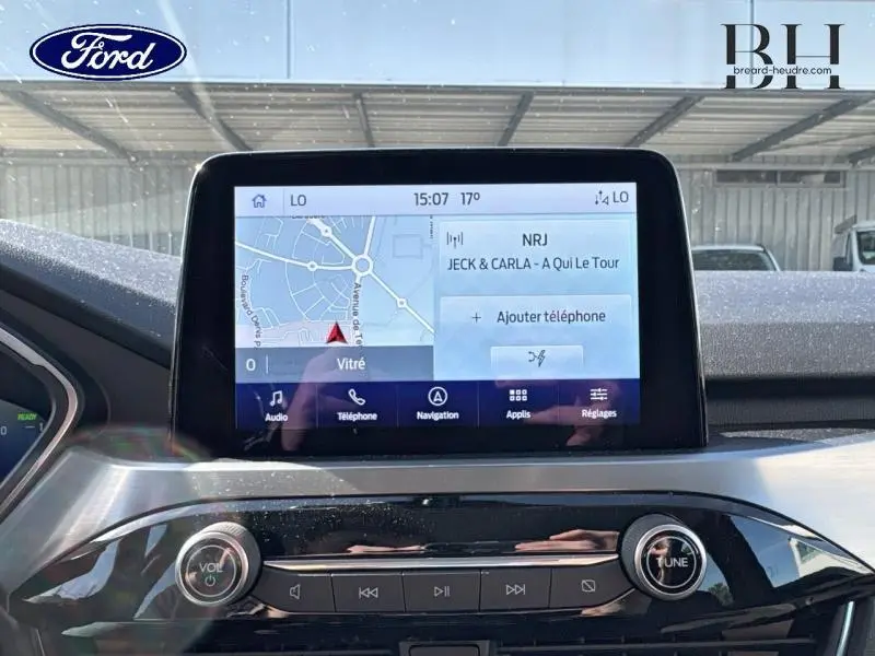 Écran tactile central du tableau de bord du Ford Kuga 2022 avec navigation et commandes multimédia visibles.