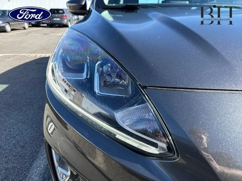 Gros plan sur le phare avant gauche du Ford Kuga 2022 gris Magnetic Métallisé avec détails LED et carrosserie brillante