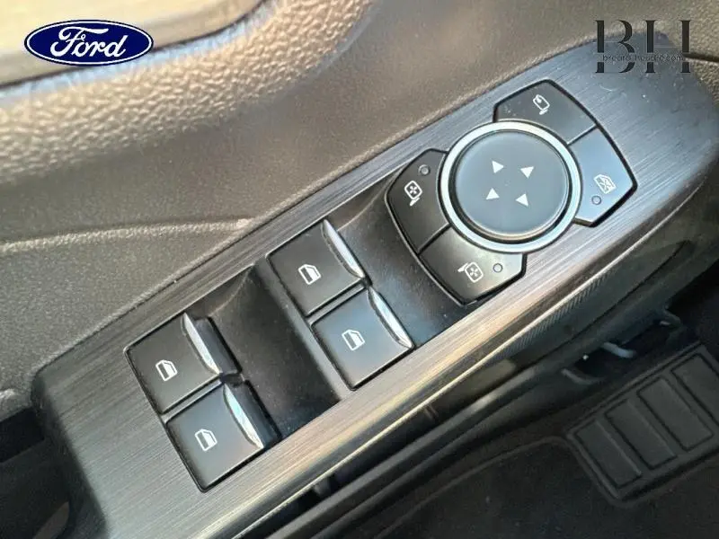 Gros plan sur les commandes de lève-vitres et rétroviseurs côté conducteur du Ford Kuga gris métallique 2022 Titanium.