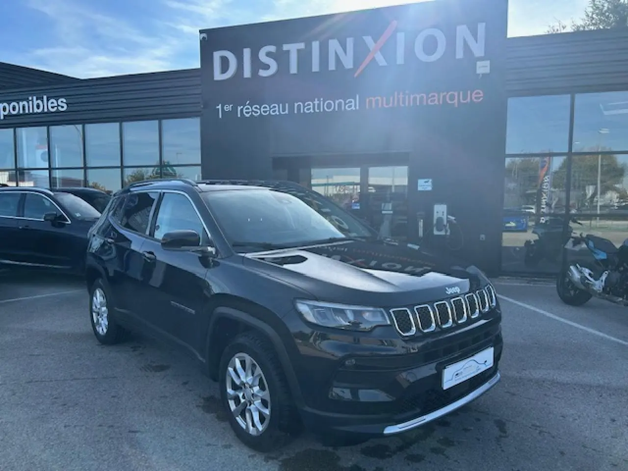 Jeep Compass noir métallisé en 3/4 avant droit, avec calandre à sept fentes et jantes alliage 17 pouces visibles.