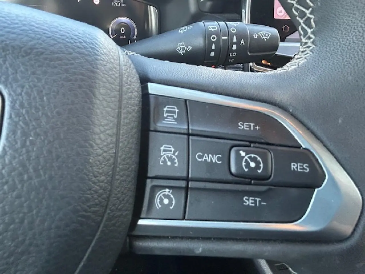 Gros plan sur les commandes de régulateur de vitesse au volant cuir noir du Jeep Compass 2021.