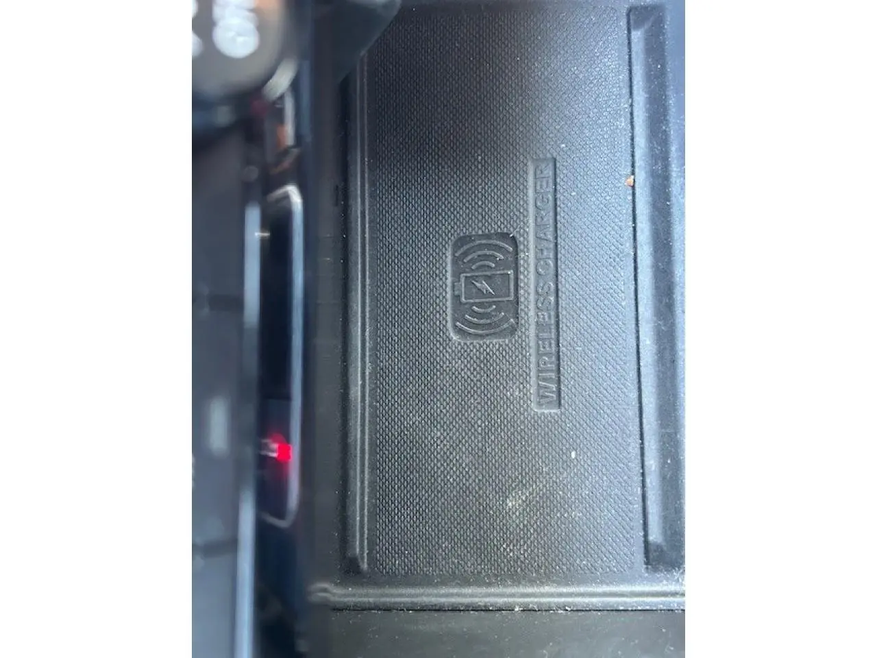 Chargeur sans fil pour smartphone en gros plan dans l'habitacle du Jeep Compass noir 2021.