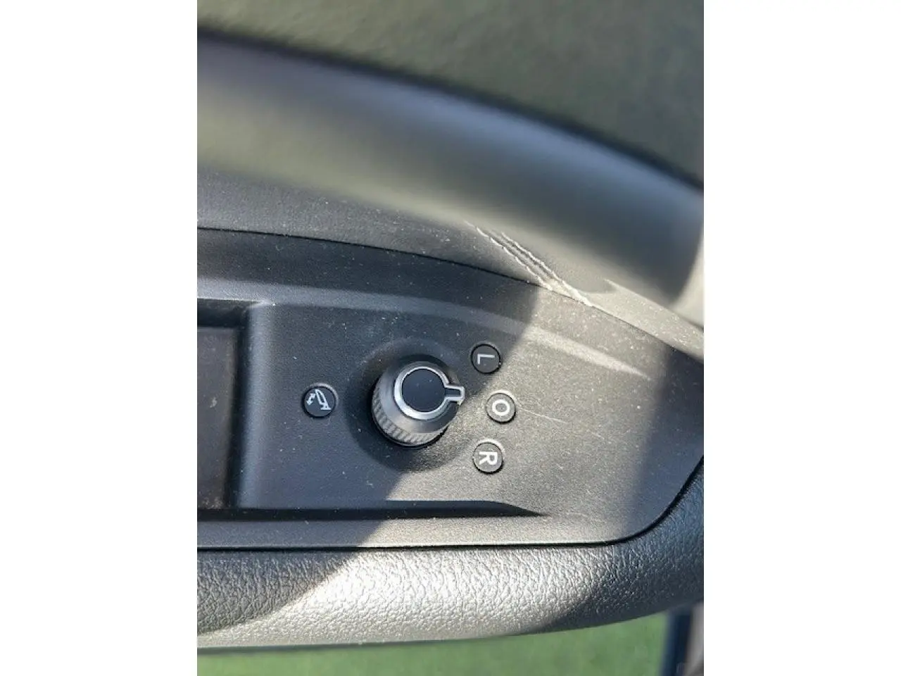 Gros plan sur la commande de réglage des rétroviseurs côté conducteur du Jeep Compass noir 2021.