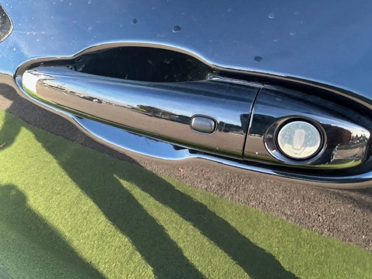 Poignée de porte noire brillante côté gauche du Jeep Compass 2021 avec serrure intégrée et reflet extérieur.