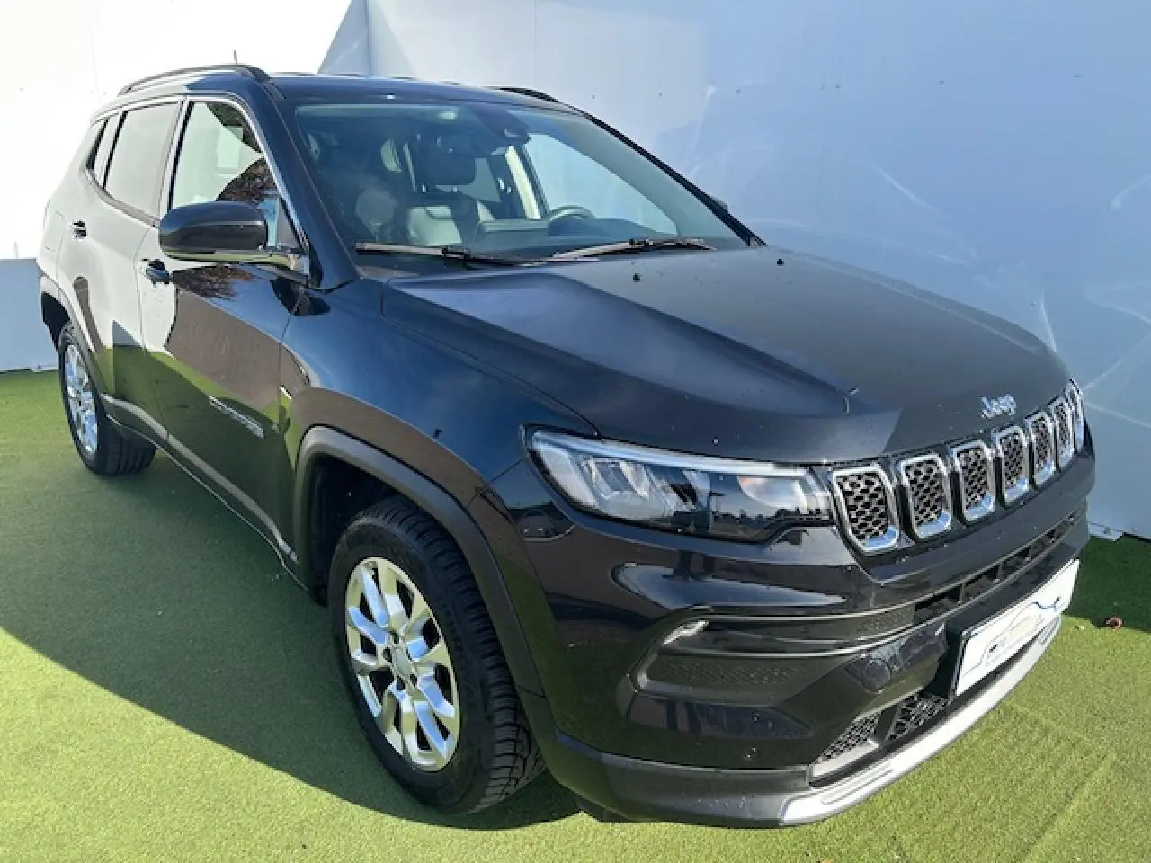 Jeep Compass noir métallisé en 3/4 avant droit, avec calandre à sept fentes et jantes alliage 17 pouces visibles.