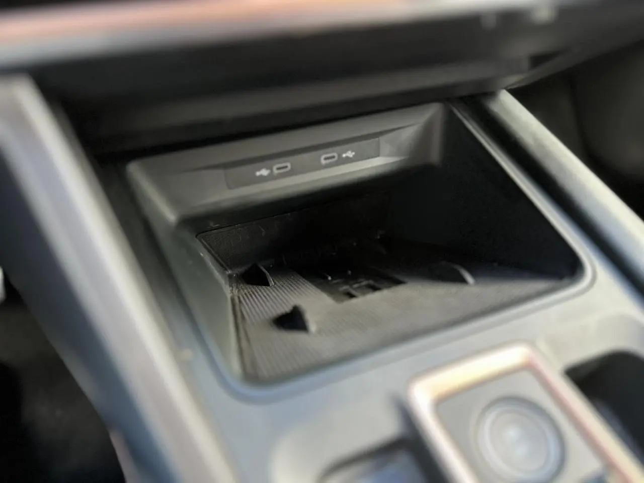 Gros plan sur la console centrale du CUPRA Formentor blanc Neige, mettant en valeur les ports USB et le rangement intégré.