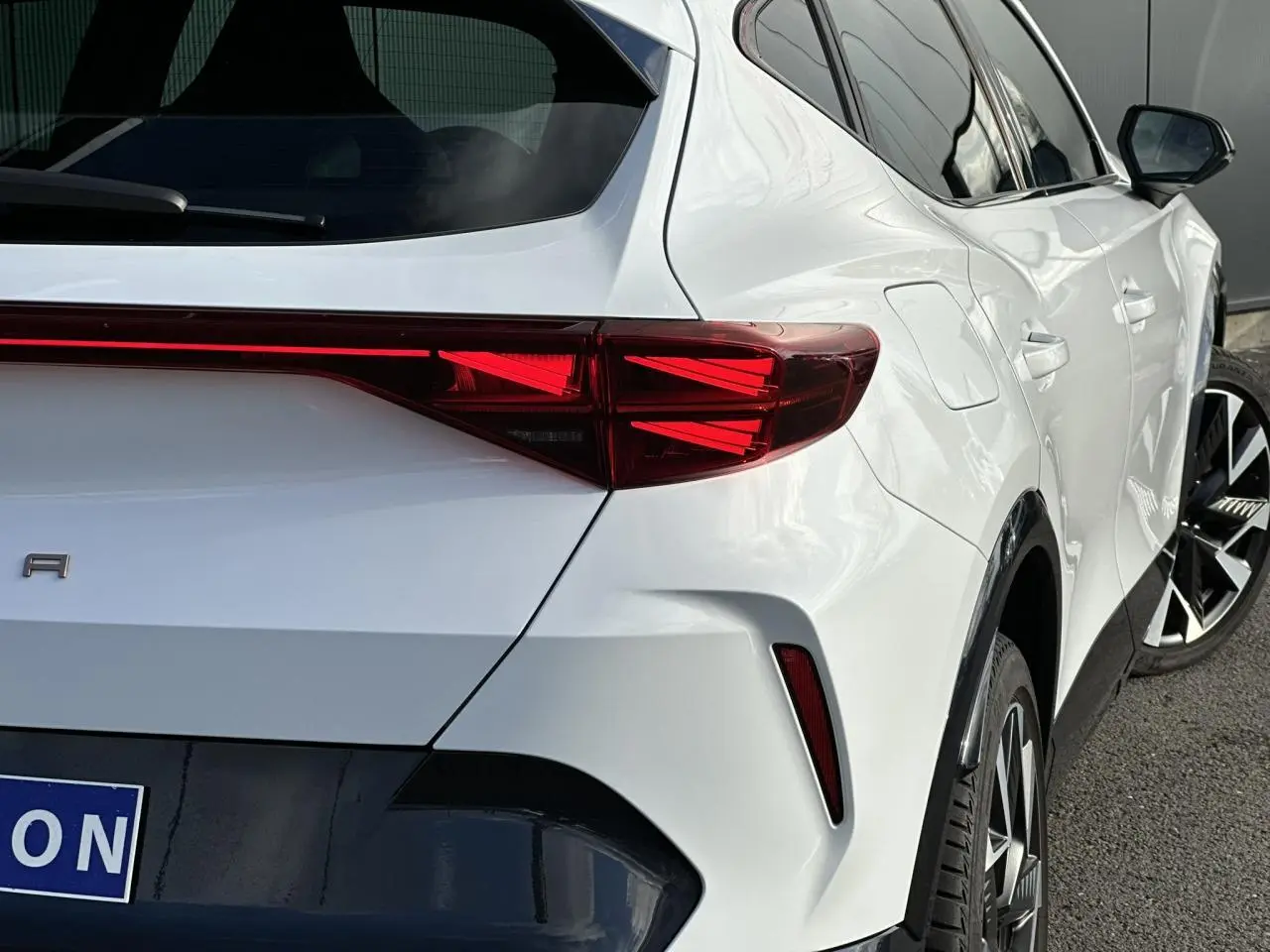 Vue 3/4 arrière droite d'une CUPRA Formentor blanc Neige avec feux arrière Tri-LED et jantes alliage 19'' Sandstorm.