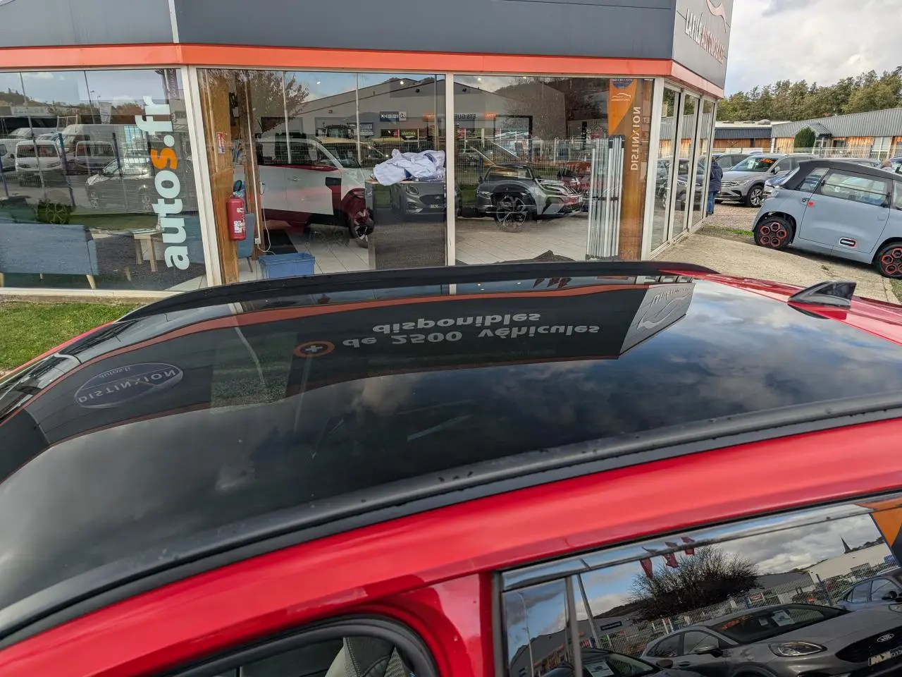 Toit panoramique en verre noir du Renault Austral rouge métallisé, vue rapprochée côté gauche du véhicule.