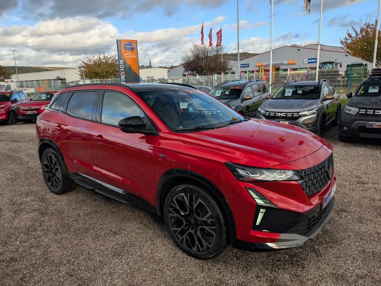 Renault Austral rouge métallisé en 3/4 avant droit avec jantes noires et calandre noir brillant Esprit Alpine.