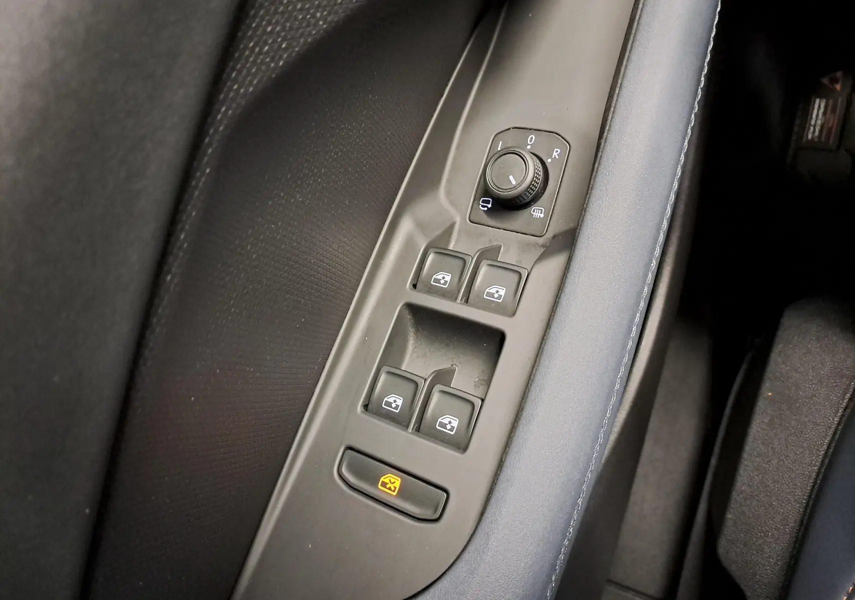 Gros plan sur les commandes des vitres et rétroviseurs côté conducteur du CUPRA TERRAMAR 2025 avec garniture intérieure bleu Cosmos.