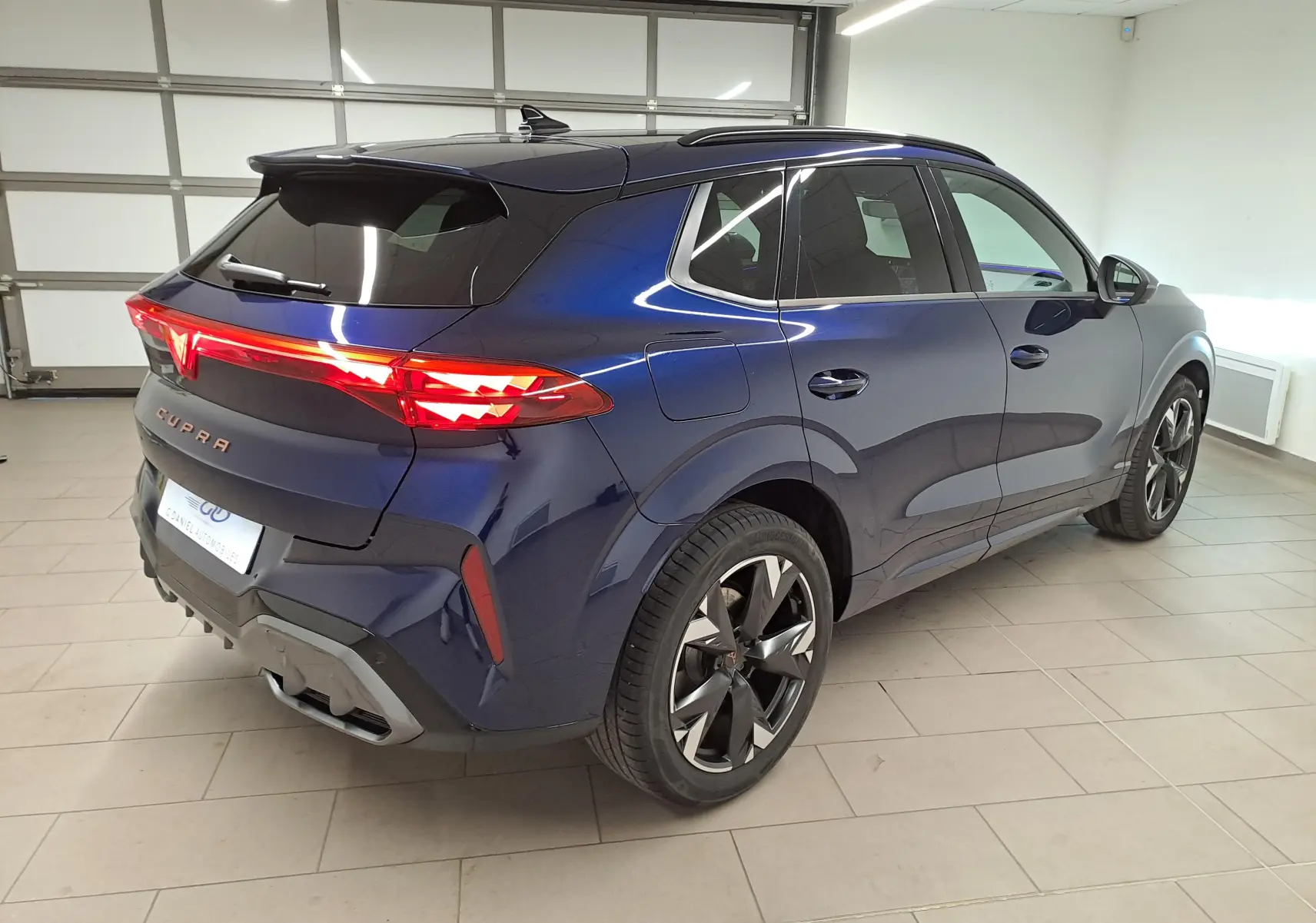 Vue 3/4 arrière droite d'une CUPRA TERRAMAR 2025 bleu cosmos avec jantes 19'' Spectrum et toit ouvrant panoramique.