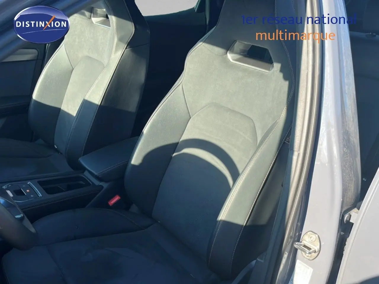 Vue intérieure des sièges avant en cuir noir du CUPRA Formentor gris magentique métal, côté conducteur avec porte ouverte.