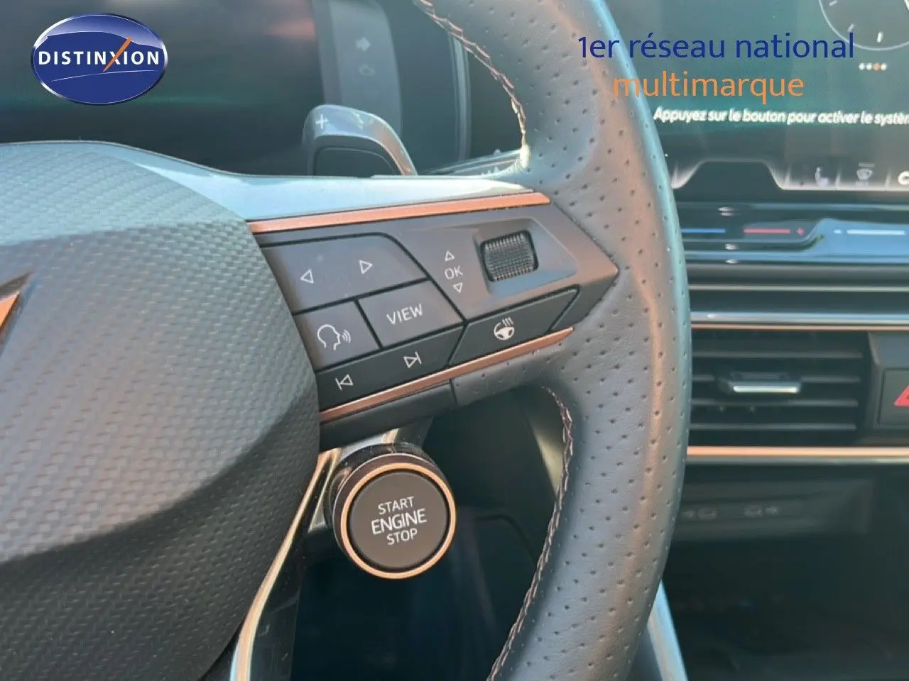 Gros plan sur le volant perforé et le bouton start/stop du CUPRA Formentor gris magnétique, avec commandes intégrées.