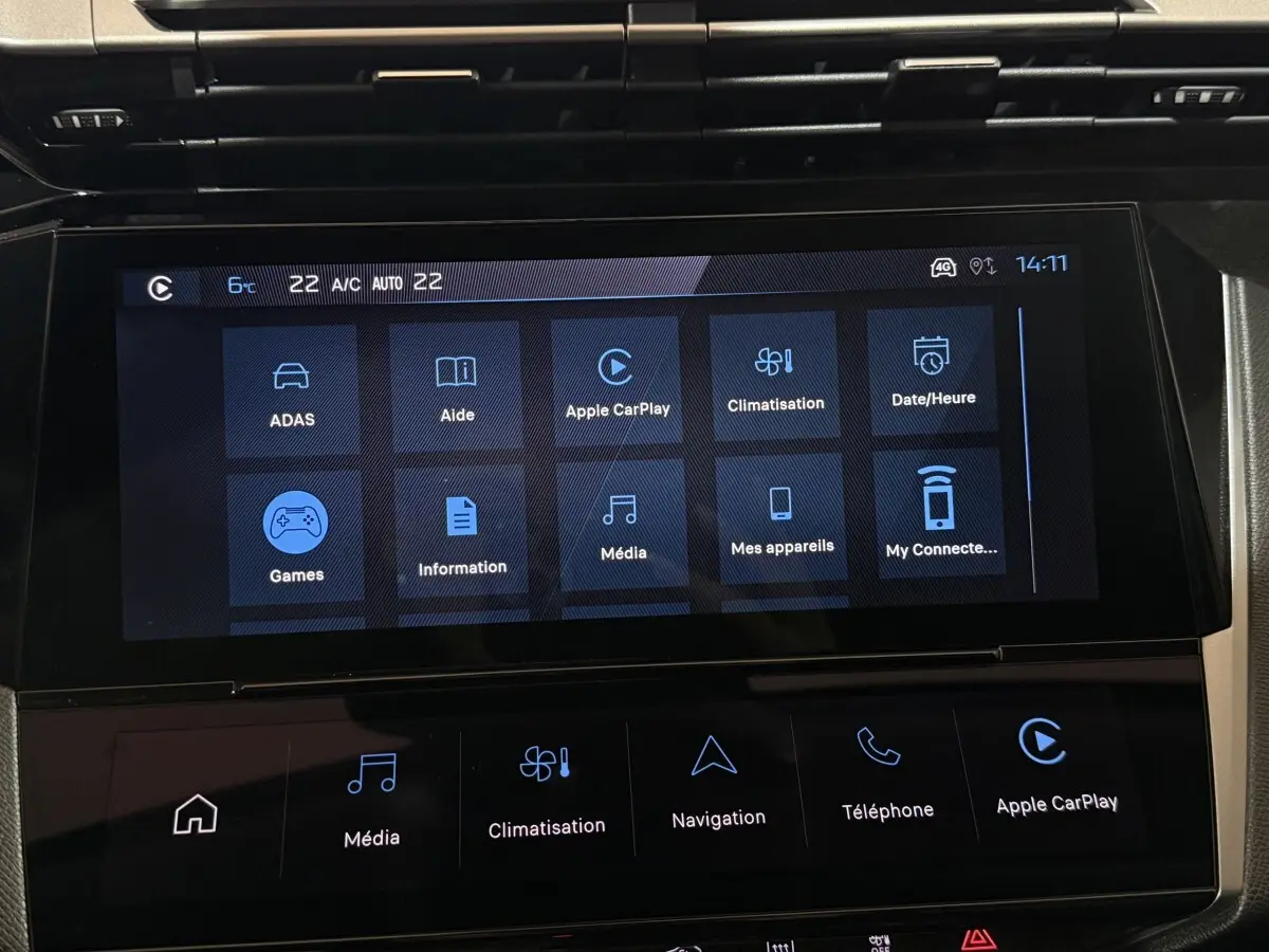 Écran tactile central de la Peugeot 308 rouge, affichant les options multimédia et climatisation en intérieur.