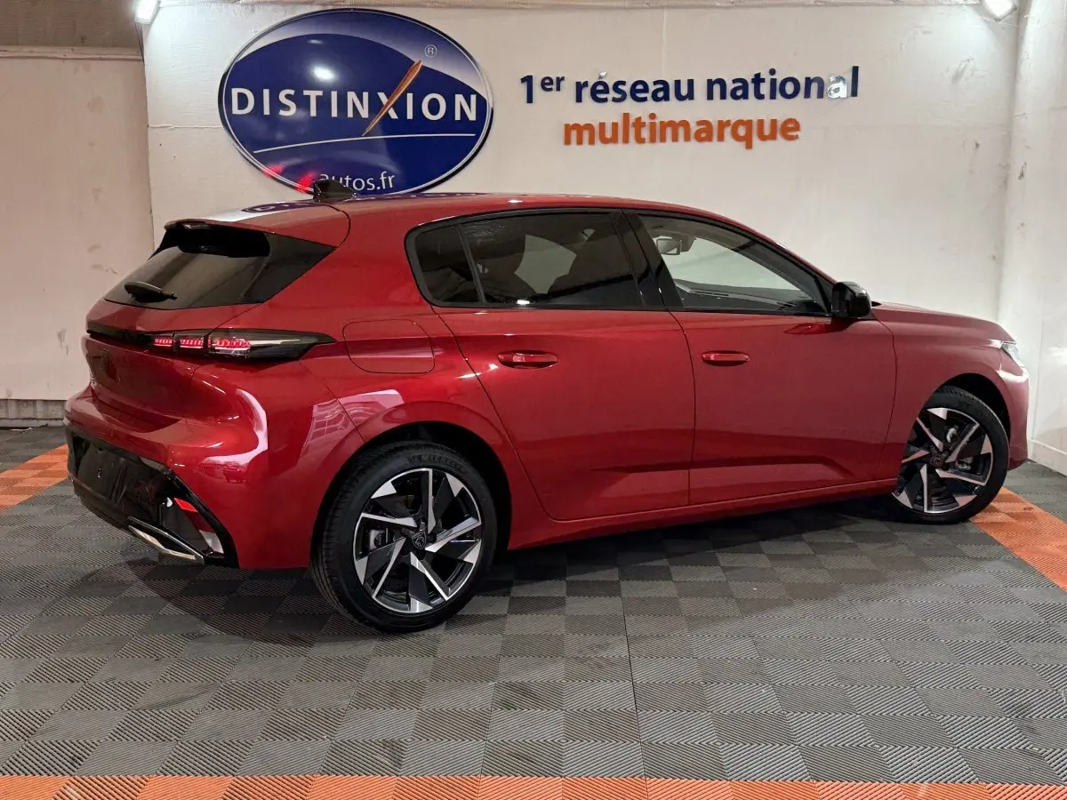 Vue 3/4 arrière droite d'une Peugeot 308 rouge 2025 avec feux LED et jantes alliage distinctives.