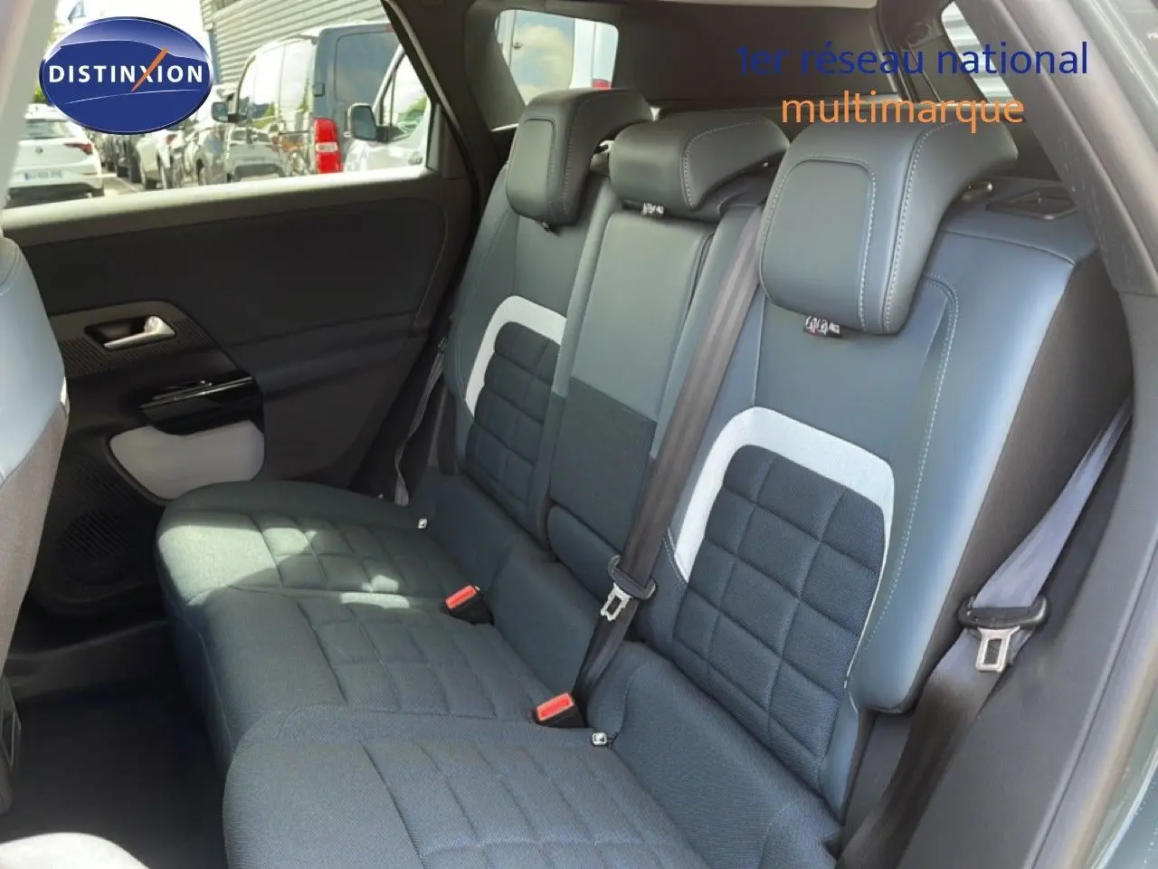 Vue intérieure sur la banquette arrière du Citroën C5 Aircross Hybrid avec sièges tissu et cuir noir, ceintures visibles.