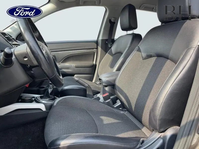 Vue intérieure côté conducteur du Citroën C4 Aircross 2016, sièges tissu noir avec cuir et console centrale visible.