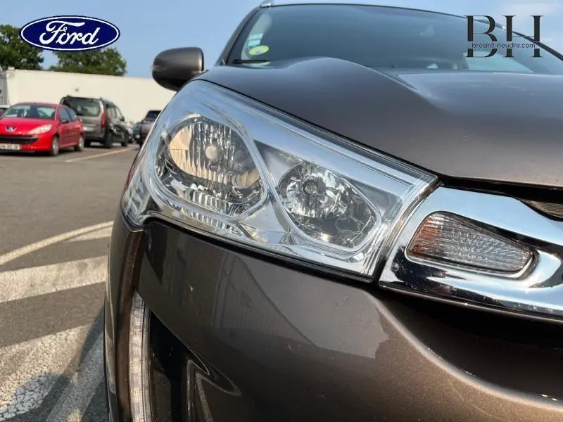 Gros plan sur le phare avant gauche d'une Citroën C4 Aircross brun Mangaro, soulignant la calandre chromée.