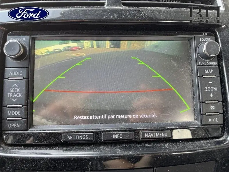 Écran de caméra de recul montrant une vue arrière avec lignes de guidage vertes et rouges sur un tableau de bord Ford.
