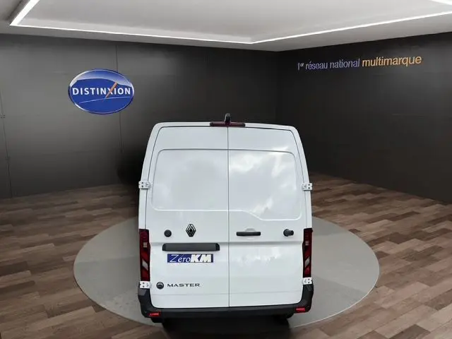 Vue arrière d’un utilitaire Renault Master blanc avec portes arrière tôlées ouvertes à 270°, en showroom.
