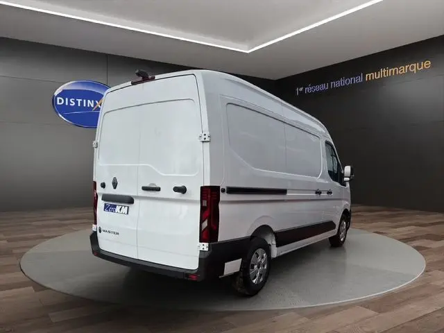 Vue 3/4 arrière droite d’un Renault Master blanc, fourgon tôlé avec feux arrière verticaux et jantes acier.