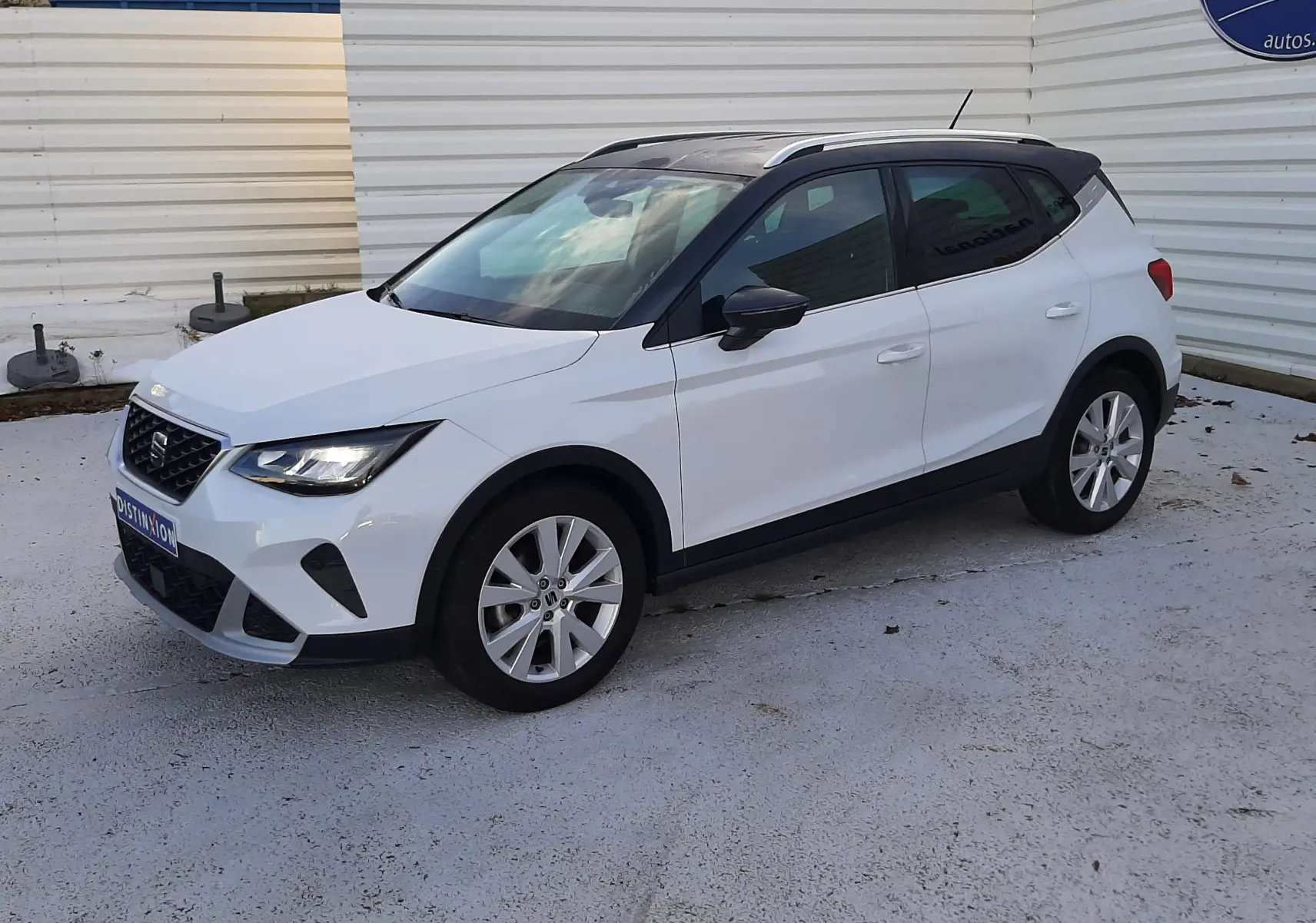 SEAT Arona blanc Nevada avec toit gris, vue 3/4 avant droit, SUV compact aux lignes modernes et jantes argentées.