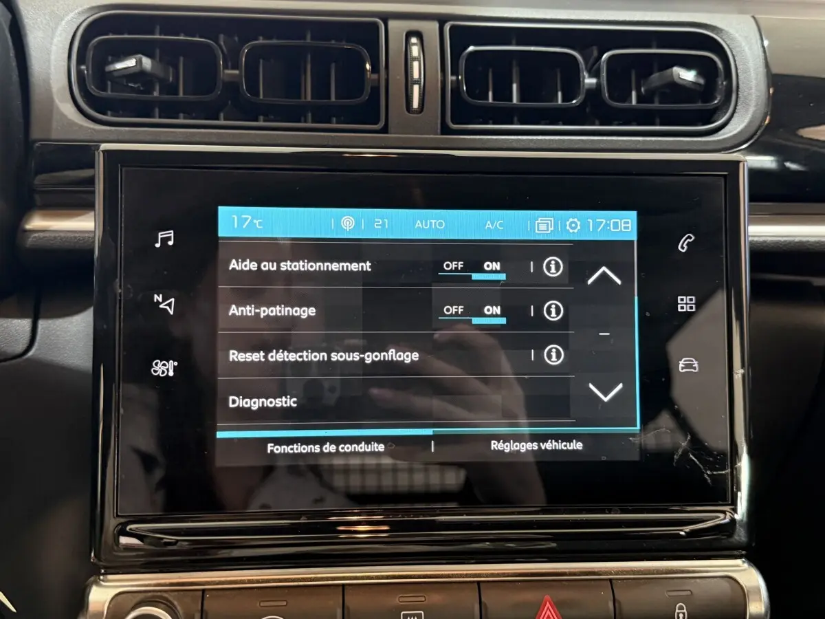 Écran tactile central de la Citroën C3 blanche, vue rapprochée du tableau de bord avec commandes activées.
