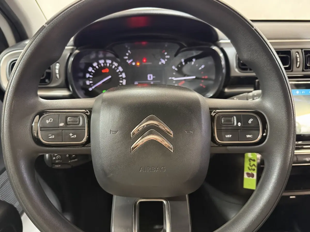 Vue rapprochée du volant multifonctions noir de la Citroën C3 2021 avec tableau de bord et commandes visibles.