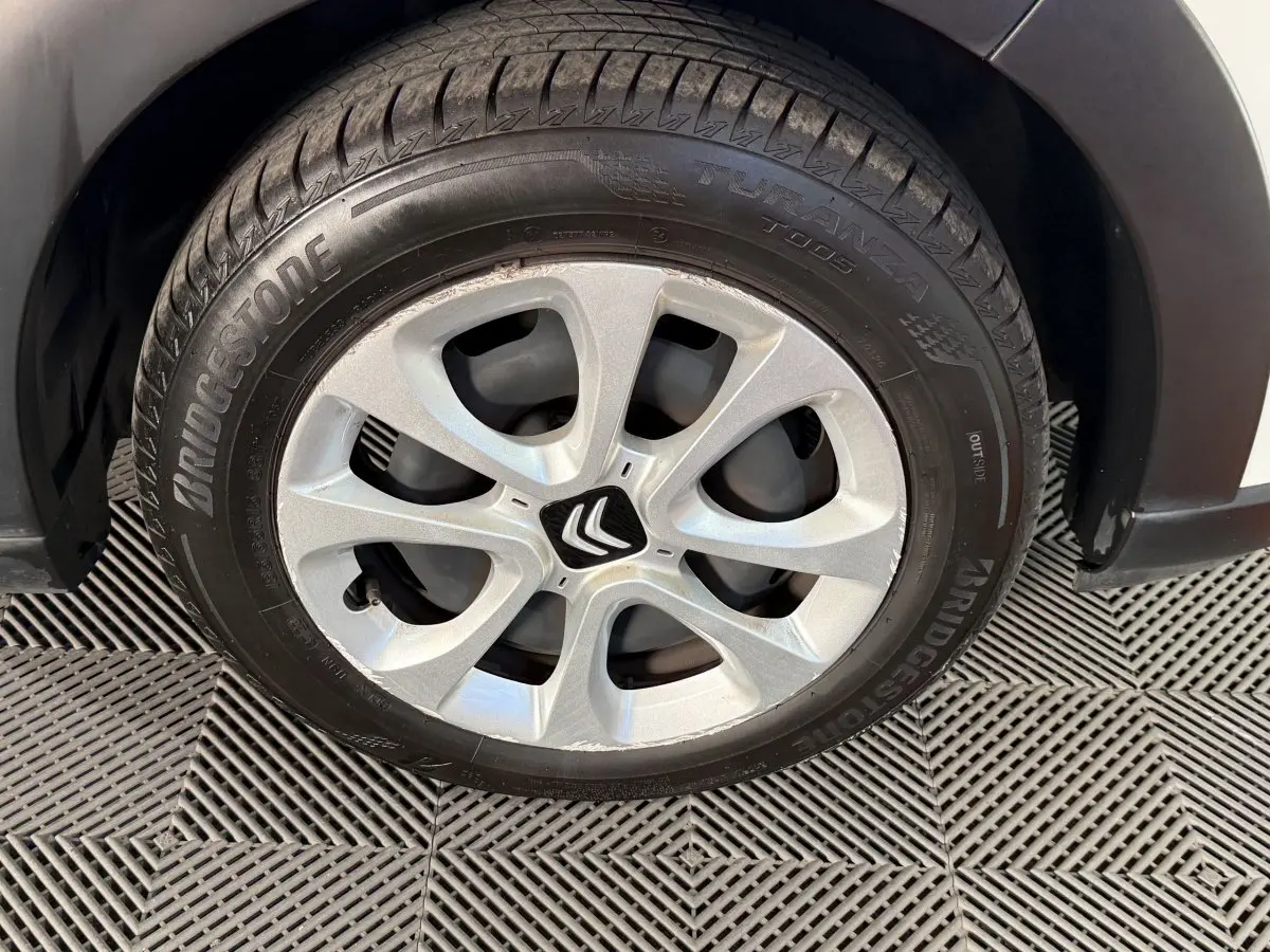 Gros plan sur la roue avant droite de la Citroën C3 blanche, avec jante argentée et pneu Bridgestone.