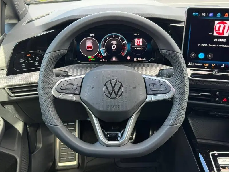 Vue rapprochée du volant cuir multifonction gris et du tableau de bord numérique de la Volkswagen Golf 1.5 eTSI R-Line 2026.