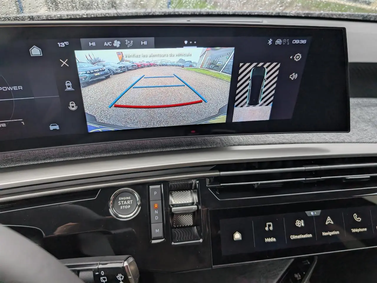 Vue rapprochée du tableau de bord du Peugeot 5008 gris Artense 2025, avec écran de recul et commandes modernes.