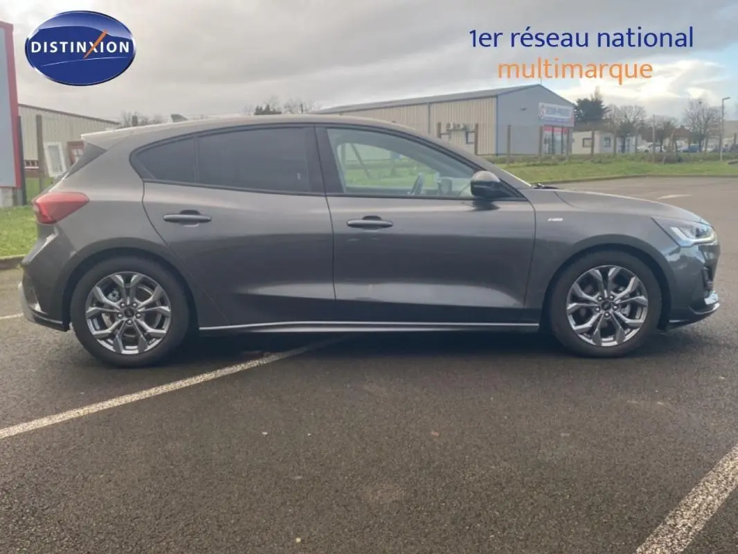 Ford Focus gris foncé vue de profil côté gauche, avec jantes alliage 17 pouces et vitres surteintées.