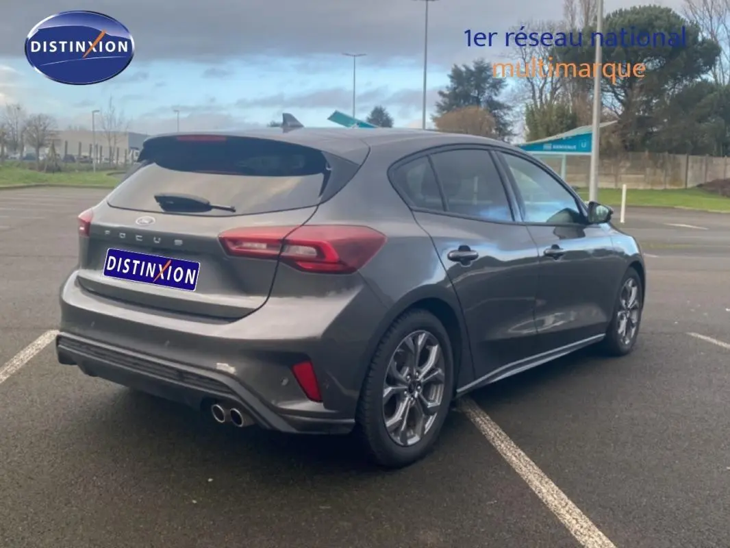 Vue 3/4 arrière droite d'une Ford Focus gris foncé 2024 avec jantes alliage 17 pouces et vitres surteintées.