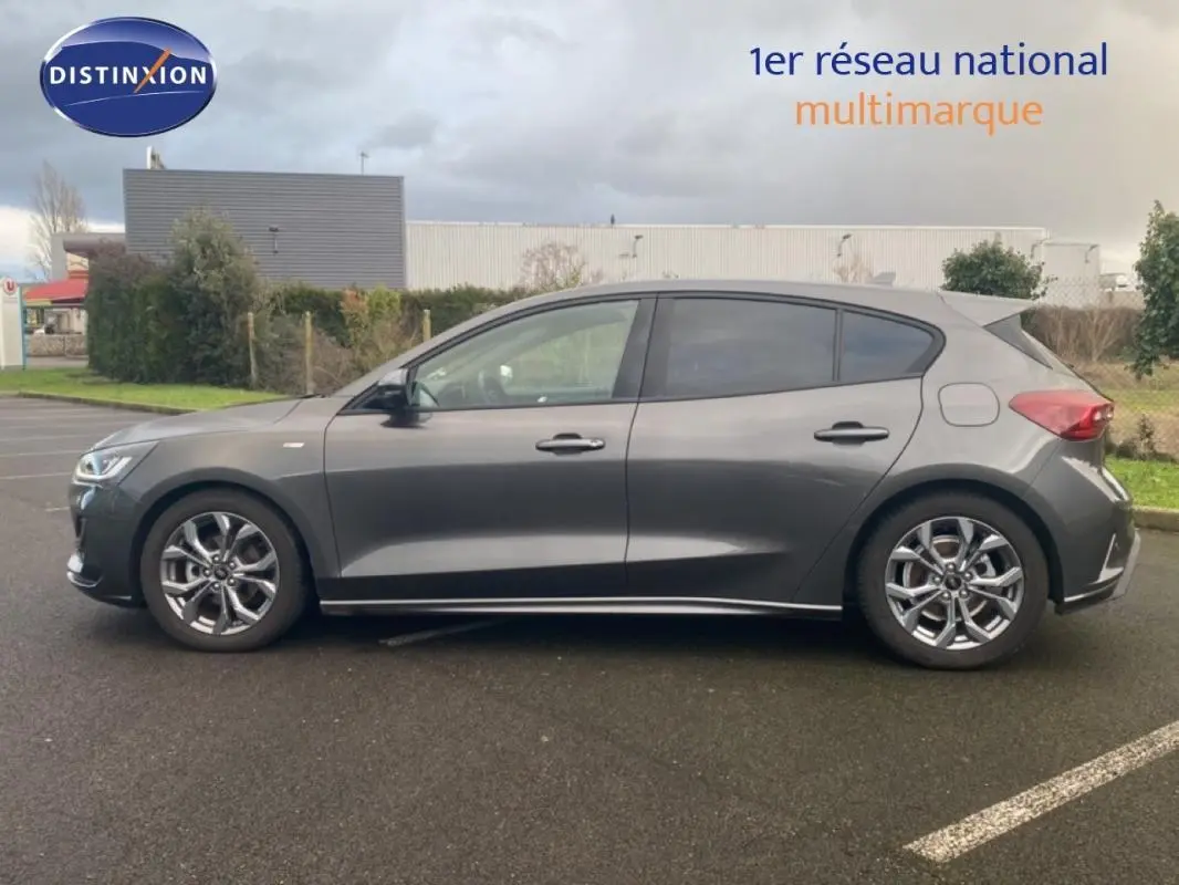 Vue de profil côté gauche d'une Ford Focus gris foncé avec jantes alliage 17 pouces et vitres surteintées.