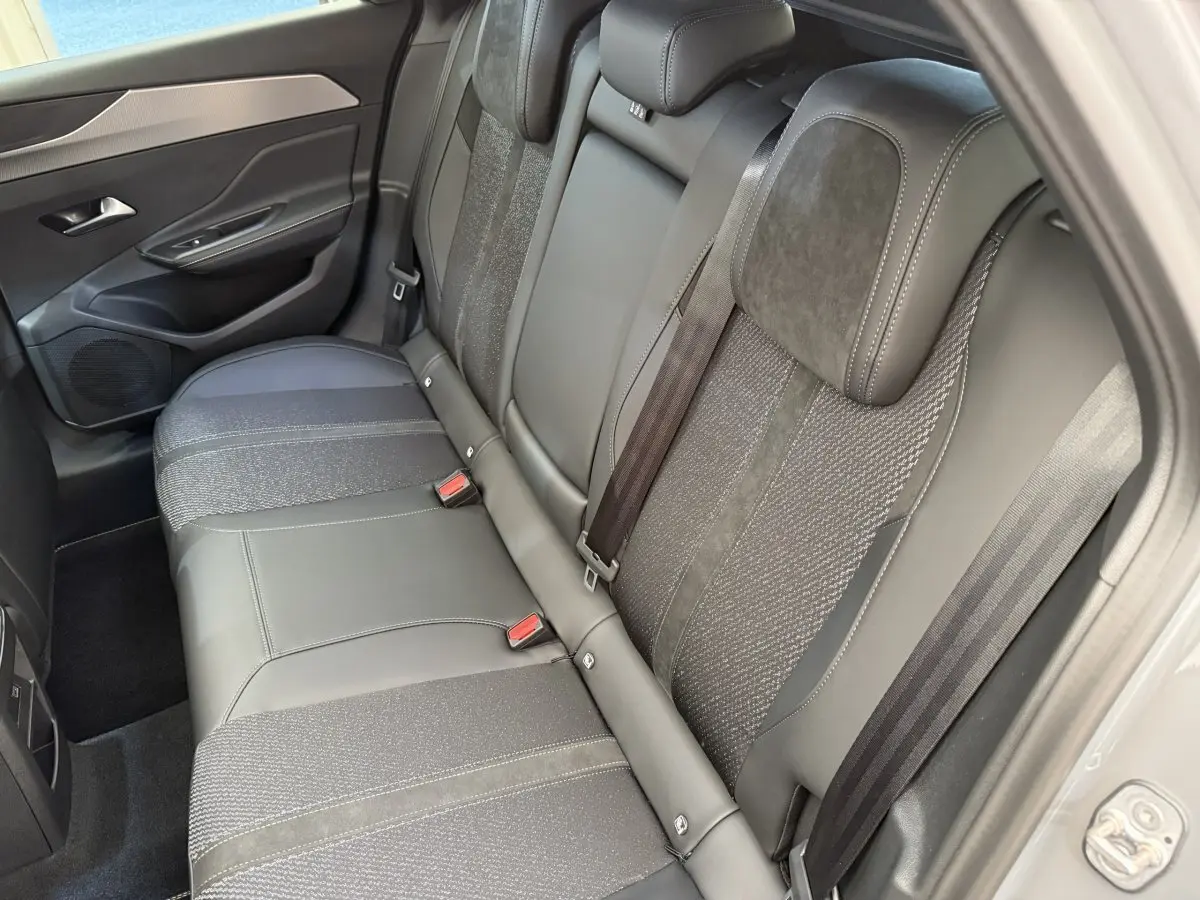 Vue intérieure côté droit sur la banquette arrière gris foncé mêlant cuir et tissu du Peugeot 308 Hybrid 2024.