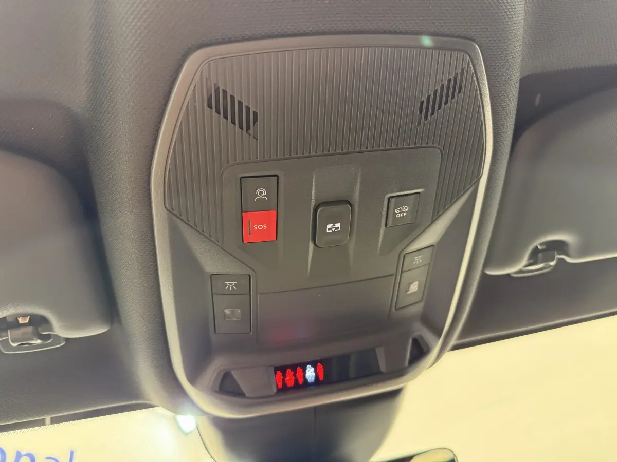Vue en contre-plongée du panneau de commandes au plafond intérieur du Peugeot 308 Hybrid gris foncé, avec bouton SOS rouge visible.