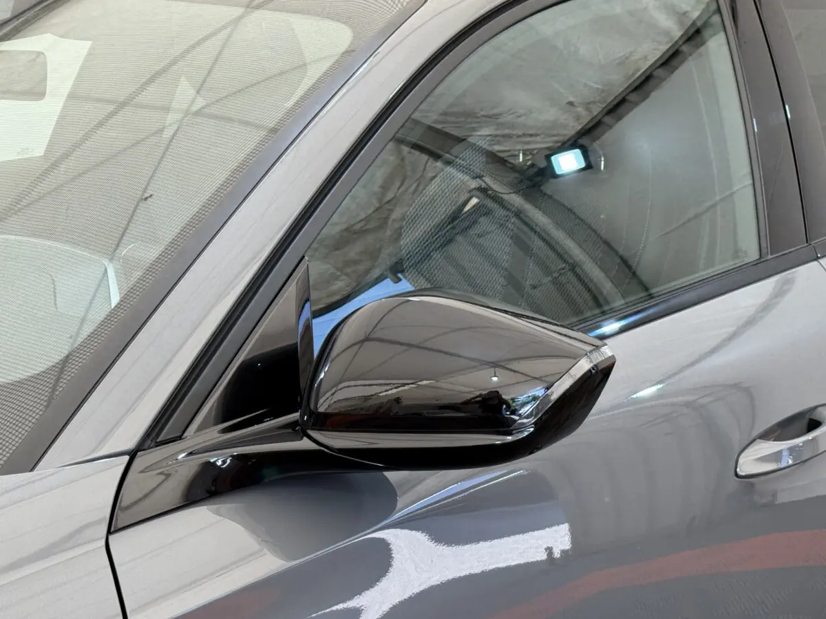 Détail du rétroviseur droit noir brillant sur la porte gris foncé d'une Peugeot 308 Hybrid 136 e-DCS6 GT 2024.