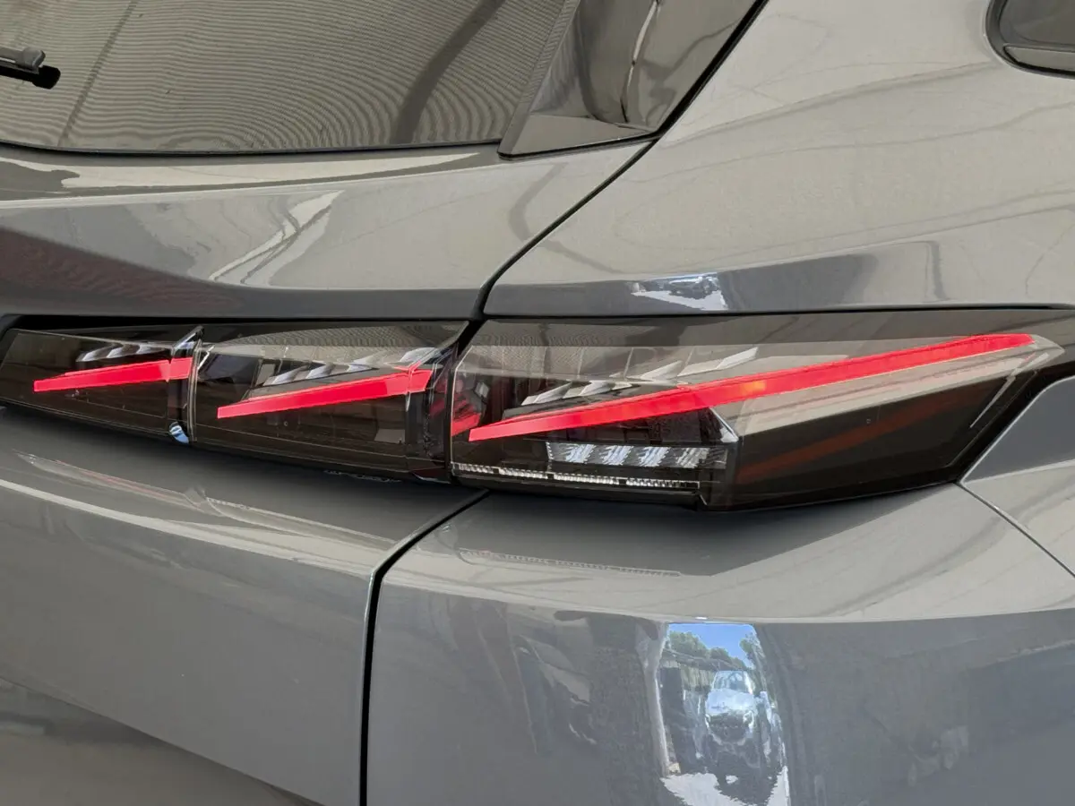 Gros plan sur le feu arrière droit rouge d’une Peugeot 308 Hybrid 136 e-DCS6 GT gris foncé 2024.