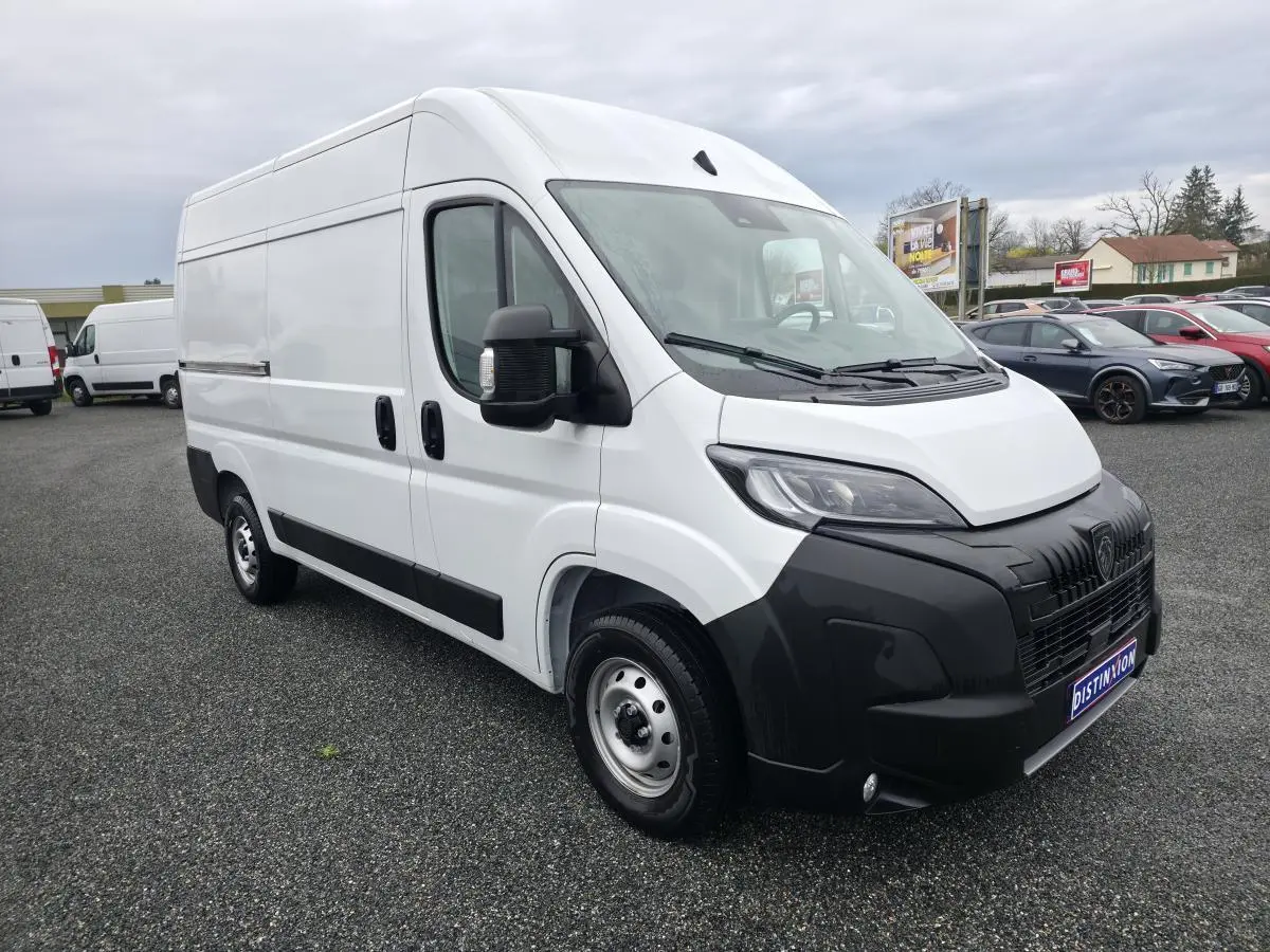 PEUGEOT Boxer Fourgon blanc en 3/4 avant droit, avec pare-chocs noir et porte latérale coulissante.