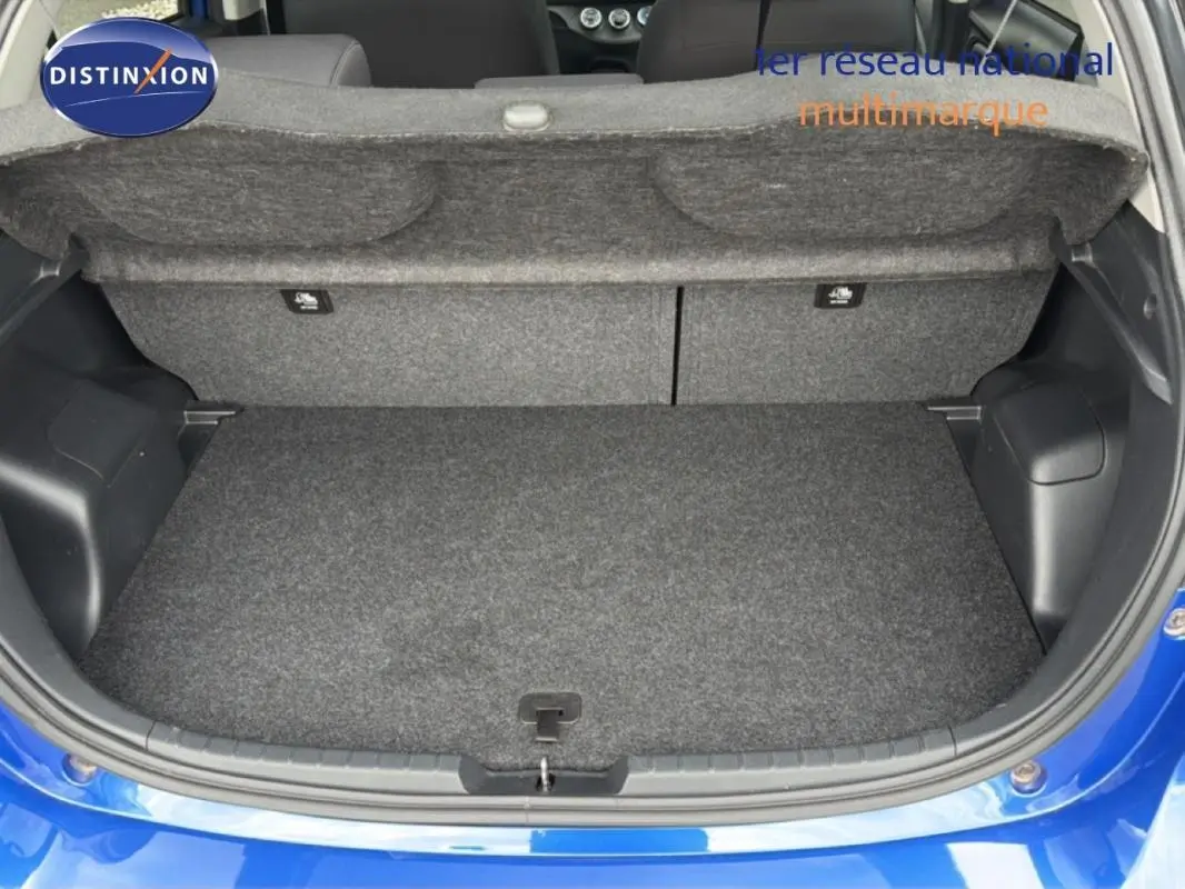 Vue arrière du coffre ouvert d'une Toyota Yaris bleu foncé 2018, montrant un espace de rangement propre et vide.