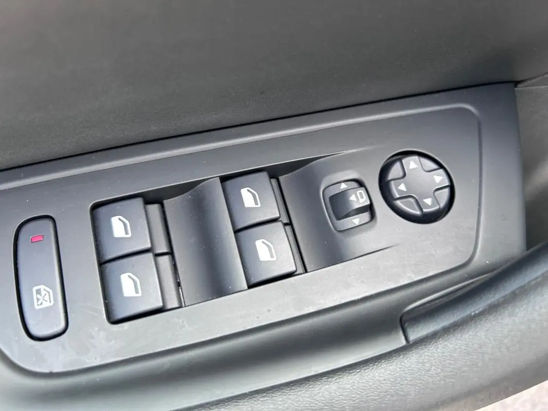 Panneau de commandes des vitres et réglages des rétroviseurs côté conducteur d'une Peugeot 508 Hybrid noire 2024.