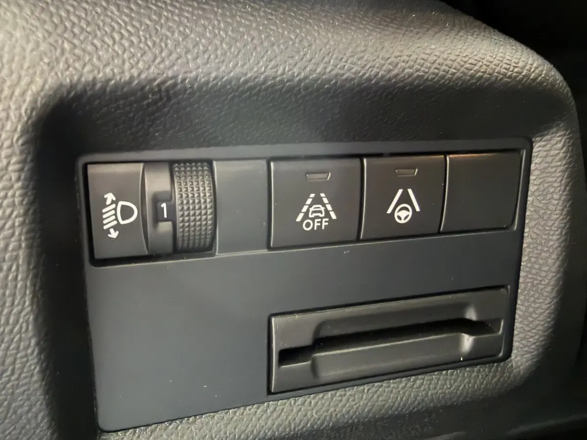 Gros plan sur les commandes noires du tableau de bord du Citroën C5 Aircross, avec réglage phares et aides à la conduite.