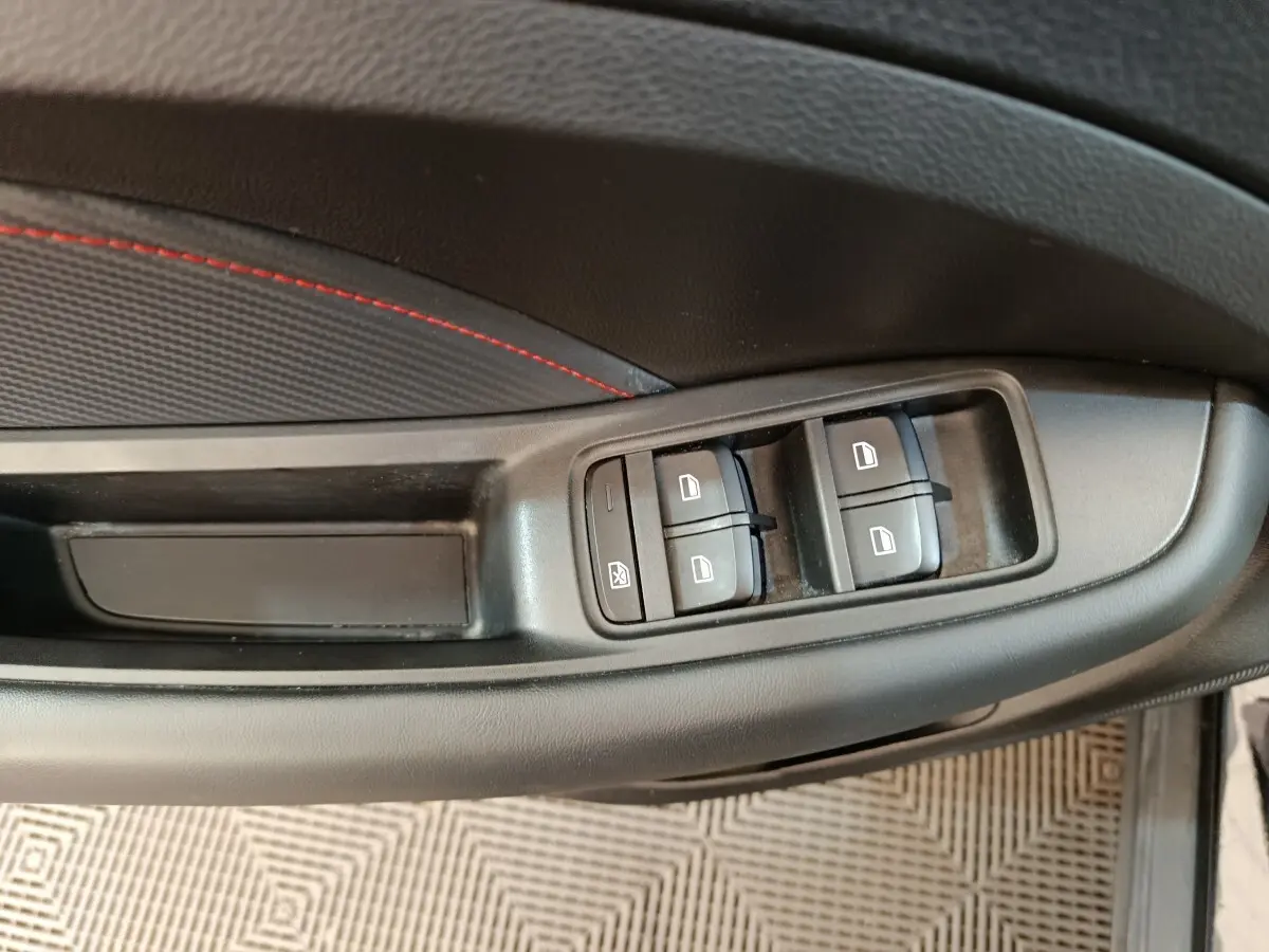 Détail des commandes de lève-vitres sur la porte côté conducteur du MG ZS Luxury noir 2024.