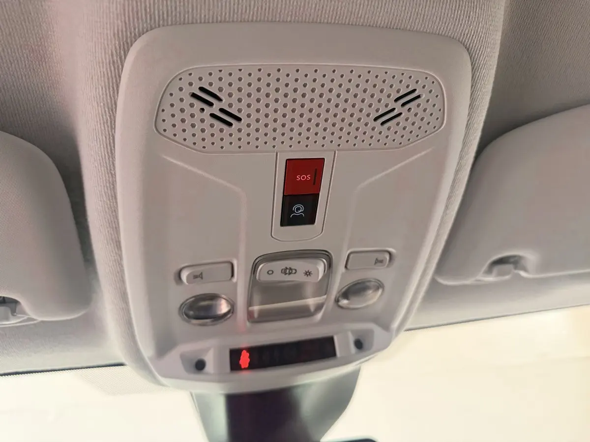 Vue en contre-plongée du plafonnier blanc avec bouton SOS et commandes d’éclairage du Peugeot 208 2025.