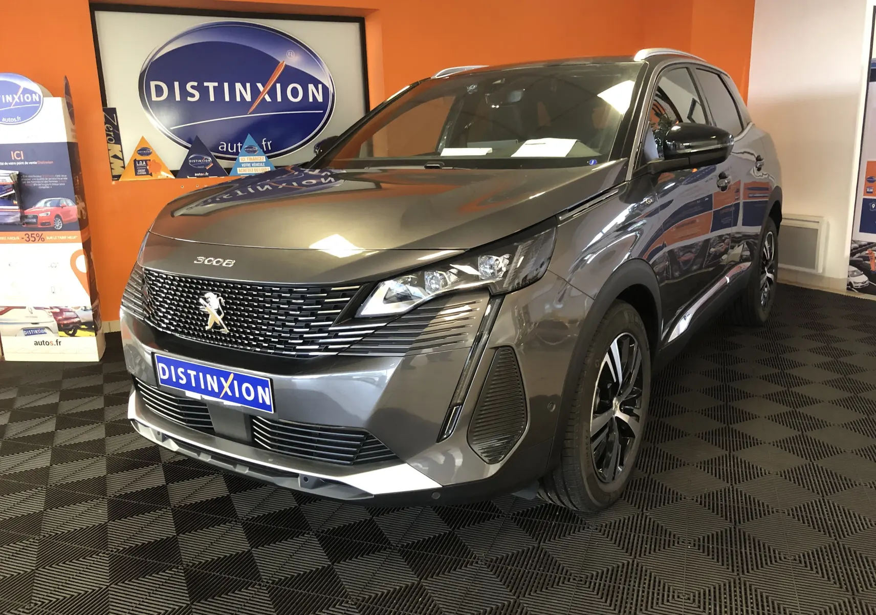 Peugeot 3008 1.2i 130 GT gris platinium avec toit noir, vue 3/4 avant droit en intérieur showroom.