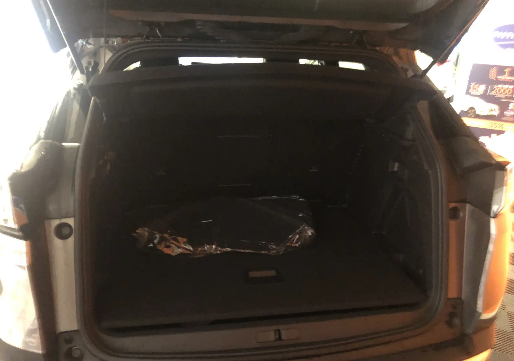 Coffre ouvert du Peugeot 3008 1.2i 130 GT gris platinium avec toit noir, vue arrière intérieure du coffre spacieux.